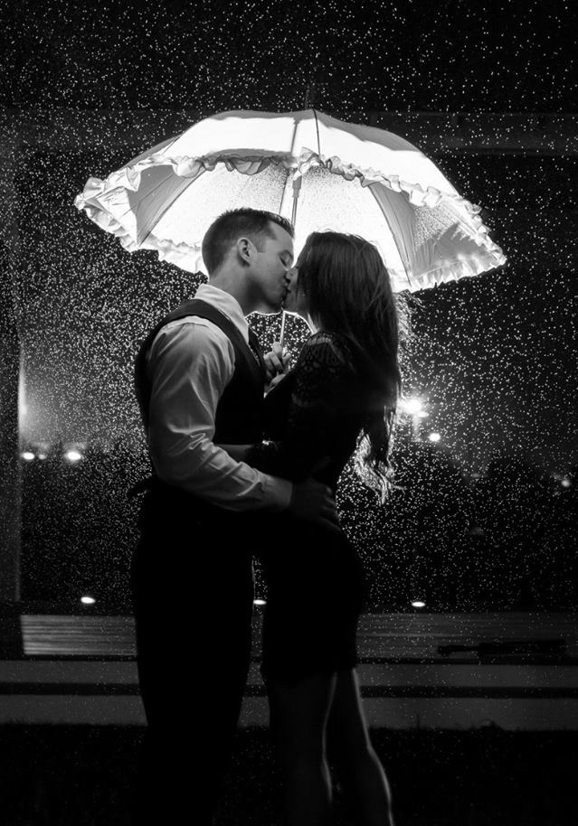 Wedding couple sharing an umbrella in the rain